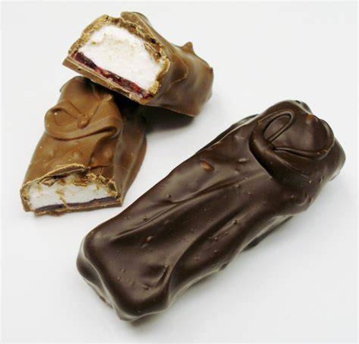 Closeup of a raspberry bar on parchment paper.
